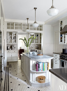 Tracy Pollan and Michael J. Fox’s New York City kitchen, designed by Gomez Associates Inc., features classic schoolhouse light fixtures, Shaker-style cabinetry, and stainless-steel and marble countertops.