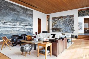 More Anselm Kiefer paintings preside over the living room, where a quartet of Marino-designed Poltrona Frau armchairs in leather and pony skin is joined by a stool covered in Icelandic sheep fur; the gilded-copper tabletop sculpture is by Hervé Wahlen, the carpet was custom made, and the floor planks are reclaimed teak.