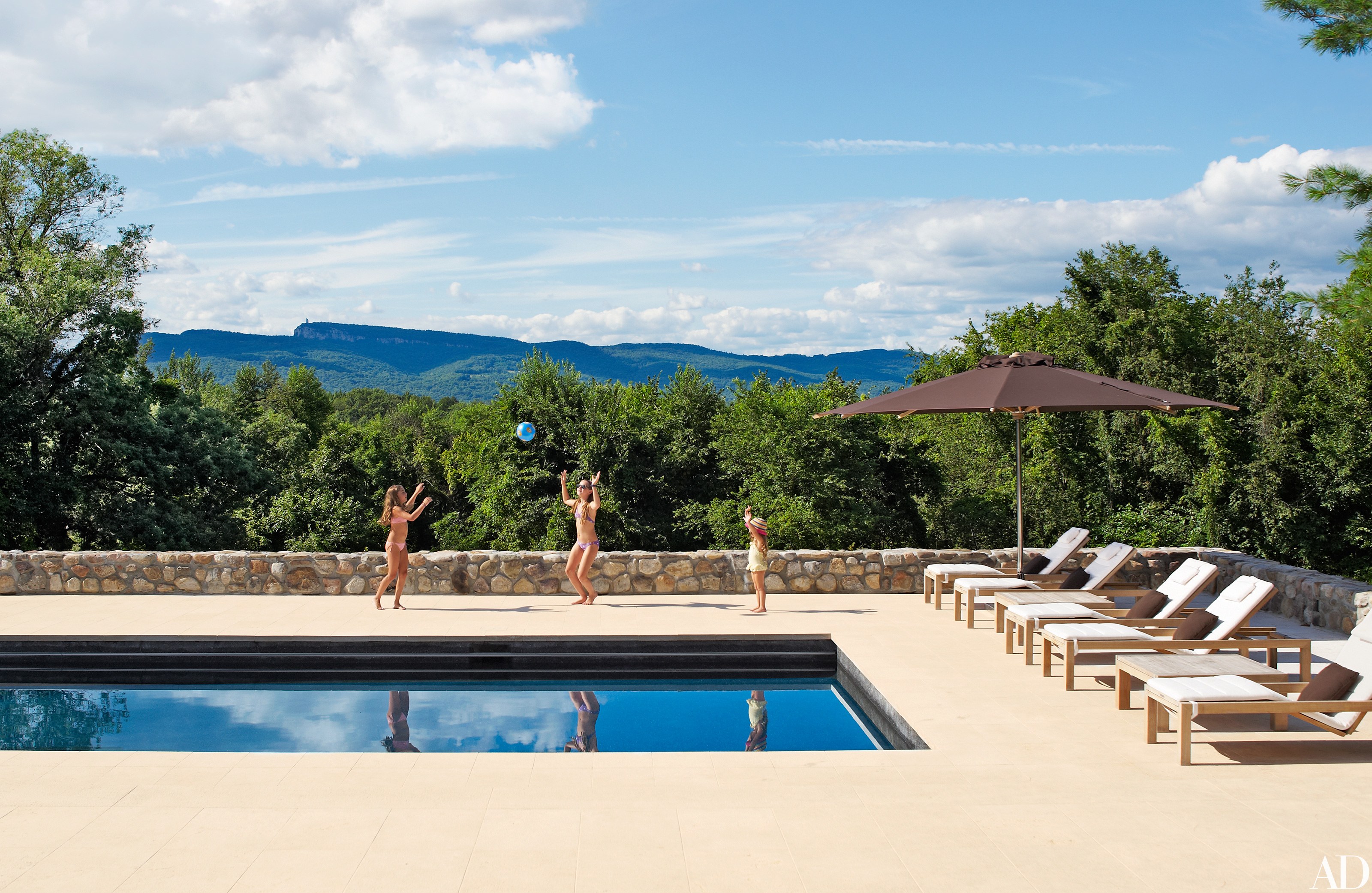 A black-plaster-lined pool, devised by Bonetti/Kozerski Architecture and Design for the New Paltz, New York, home of movie director Shawn Levy and his family, overlooks the Shawangunk Mountains. The expansive terrace is sheathed in pietra d’Istria, an Italian limestone.