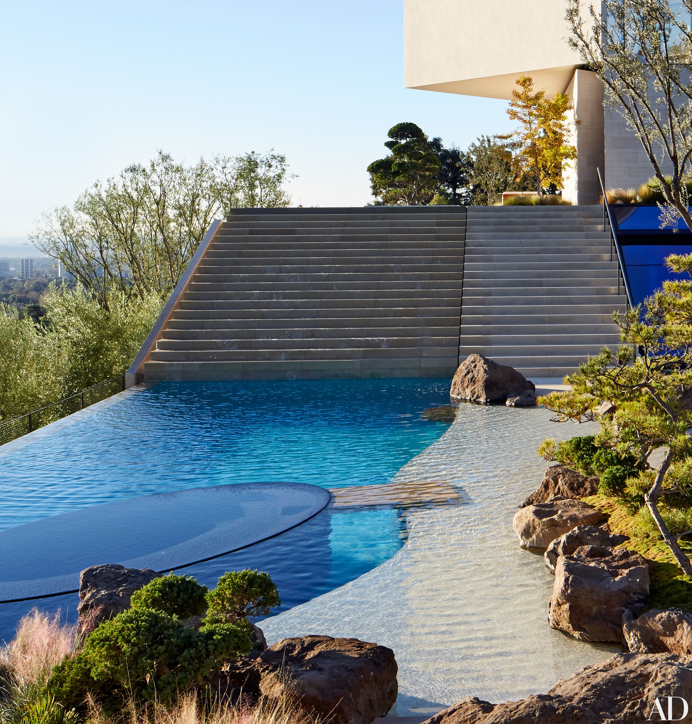 An integral part of its hillside setting, the infinity pool at filmmaker Michael Bay’s Los Angeles residence was designed by architect Chad Oppenheim and executed by the firm Rios Clementi Hale Studios; it features an oval inset hot tub.